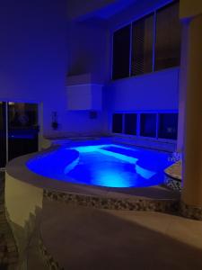 a large swimming pool in a room with blue lighting at @47 Galpin in Port Elizabeth