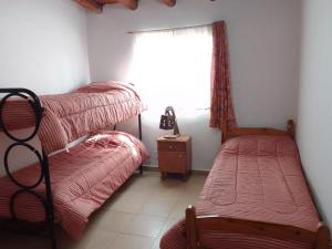 a bedroom with two twin beds and a window at Cabaña Don Jas in San Agustín de Valle Fértil