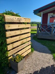 een houten hek met een mand met planten naast een huis bij Älgbergets Bed & Breakfast in Ucklum