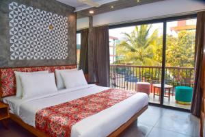 a bedroom with a large bed and a balcony at Caravan Baga Aqua Resort in Baga