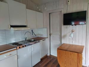 eine Küche mit weißen Schränken und einem Waschbecken in der Unterkunft Älgbergets Bed & Breakfast in Ucklum