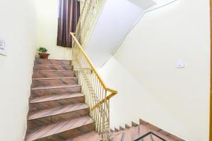 a staircase in a house with a gold handrail at FabExpress The Hudco Grand in Patna