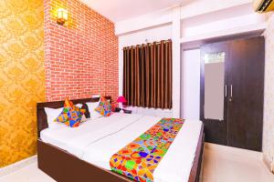 sypialnia z łóżkiem i ceglaną ścianą w obiekcie FabExpress The Hudco Grand w mieście Patna