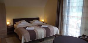a bedroom with a bed with white pillows and a window at Romanówka pod Śnieżką in Kowary