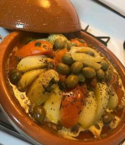 a bowl of food with peas and vegetables on a stove at maison d'hôtes Le petit jardin Marrakech in Marrakech