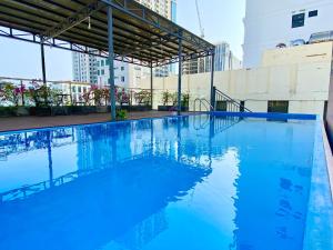 a large pool with blue water in a building at Hummer Hotel & Apartment Da Nang Beach in Da Nang