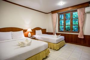 two beds in a room with a window at Neptune's Villa in Haad Rin