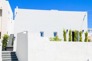 a white wall with stairs in front of a building at City Center Suites in Fira