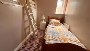 a small bedroom with a bunk bed and a ladder at Richard's Home in Kidderminster