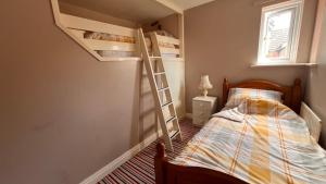 ein Schlafzimmer mit einem Etagenbett mit Leiter in der Unterkunft Richard's Home in Kidderminster