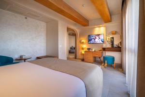 Al Masa Hotel El Sokhna في العين السخنة: غرفة نوم بسرير ومكتب وتلفزيون