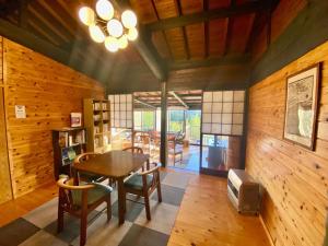 comedor con paredes de madera, mesa y sillas en DeepSpot - Vacation STAY 19274v en Minamioguni