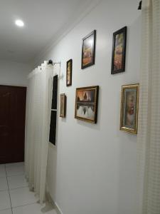 una pared blanca con cuadros en una pared con cortinas en annies inn homestay en Kochi