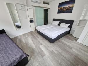 una camera con un grande letto e uno specchio di Hotel FeWo-HM a Ramstein-Miesenbach