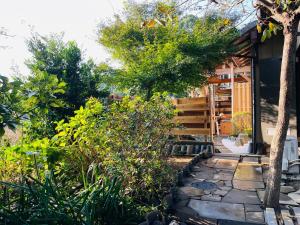 un jardín con una pasarela de piedra junto a una casa en Izakaya inn "Tsubaki" - Vacation STAY 14130 en Chiba