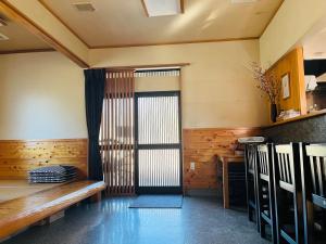 um quarto com um banco e uma porta de vidro deslizante em Izakaya inn "Tsubaki" - Vacation STAY 14130 em Chiba