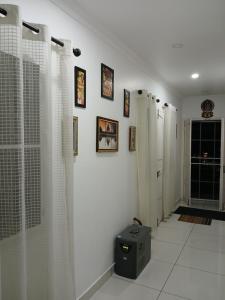uma casa de banho com paredes brancas e cortinas de chuveiro brancas em annies inn homestay em Cochin