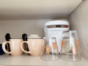 a shelf with cups and a toaster and some cups at 关西机场直达 i Home Osaka URBAN NOOK 舒适双床房 天下茶屋站步行3分钟 in Osaka