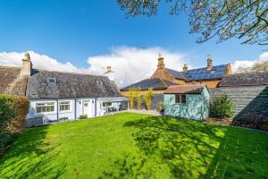 an exterior view of a house with a green yard at Riverside Retreat in Dumfries in Dumfries
