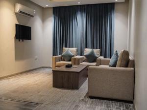 فندق ليان بارك Lian Park Hotel في الخبر: غرفة معيشة مع كنبتين وتلفزيون
