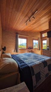 a bedroom with a large bed with a wooden ceiling at Refúgio Rodreipe in São Bento do Sapucaí