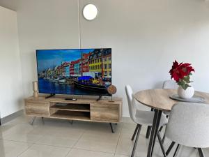 Una sala de estar con un televisor en un centro de entretenimiento de madera. en Marina View Holiday Apartment - Beautiful Views, en Larrakeyah