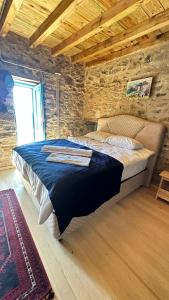a bedroom with a large bed in a brick wall at Fintoz Butika in Karaburun