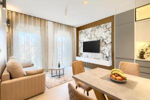 Una sala de estar con una mesa de comedor y un televisor. en Posh Pula - Luxury Apartments, en Pula