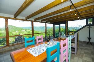 a dining room with a table and chairs and windows at Conacul Fruntea cu ceru in Iloviţa