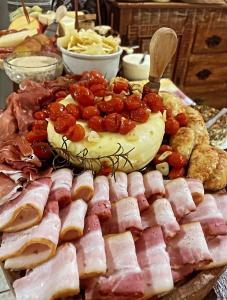 a platter of food with ham and cheese on a table at Pouso das Flores -350m Maria Fumaça in Tiradentes