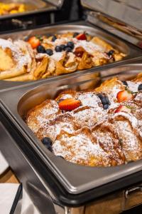 two trays of pastries with blueberries and powdered sugar at Belmar Park Resort & SPA in Władysławowo