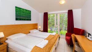 um quarto de hotel com uma cama, uma secretária e uma janela em Hótel Eyvindará em Egilsstadir