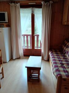 een woonkamer met een bank, een tafel en een raam bij Studio Cabine, plein centre de Valloire in Valloire +3 foto's