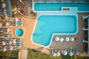 uma vista sobre uma piscina e cadeiras de praia em Malia Bay Beach Hotel & Bungalows em Malia