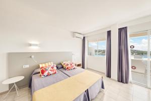 1 dormitorio con cama, mesa y ventana en Apartamentos Vista Club en Santa Ponsa