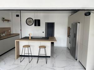 une cuisine avec un comptoir et deux tabourets dans l'établissement Appartement offrant une vue exceptionnel sur le jaizkibel et l'océan, à Hendaye