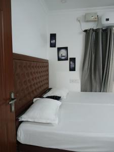 um quarto com duas camas com fotografias na parede em annies inn homestay em Cochin