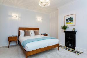 a bedroom with a large bed and a night stand at Veeve - Village Beauty in London