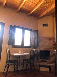 a table and chairs in a room with a fireplace at Casa Mediodía in Villanueva de los Caballeros