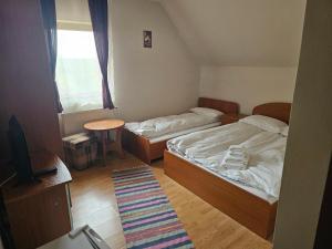 Habitación pequeña con 2 camas y TV. en Pensiunea Printul Vlad, en Sibiel