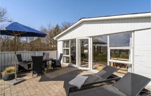 een patio met een tafel en stoelen en een parasol bij Awesome Home In Thyholm With Kitchen in Thyholm