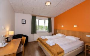 1 dormitorio con cama, escritorio y ventana en Hótel Eyvindará en Egilsstadir