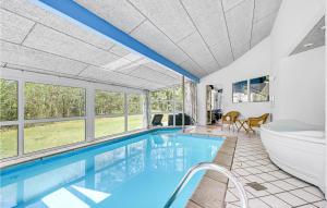 une maison avec une piscine et une baignoire dans l'établissement Awesome Home In Glesborg With Kitchen, à Fjellerup Strand