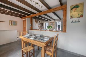 a dining room with a wooden table and chairs at À 400m des marais de Guérande - Maison de paludier in Kermoisan