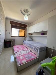 una camera con un grande letto e un tappeto rosa di Charmant appartement bien situé. a Martil