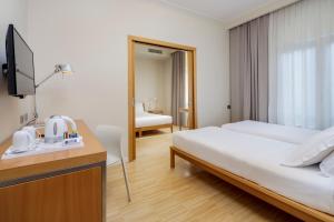 una camera d'albergo con letto e scrivania con TV di Best Western Plus Hotel Bologna a Mestre