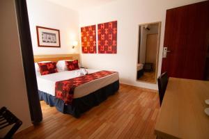 Un dormitorio con una cama con almohadas rojas. en Hotel Santa Maria en Praia