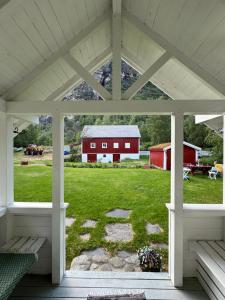 uma vista para um celeiro vermelho a partir do alpendre de uma casa em Aobrio Holidayhouse, authentic norwegian farmhouse close to Flåm em Lærdalsøyri