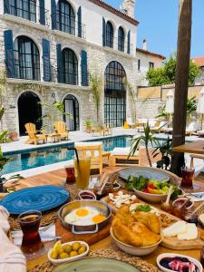 a table with breakfast food on it next to a pool at Rhea Alaçatı Boutique Hotel in Alacati