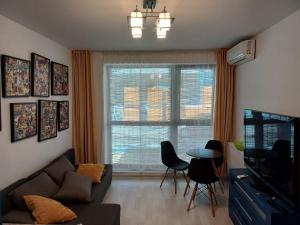ママイア・ノルドにあるPanoramis Apartamentのソファとテーブルと窓のあるリビングルーム